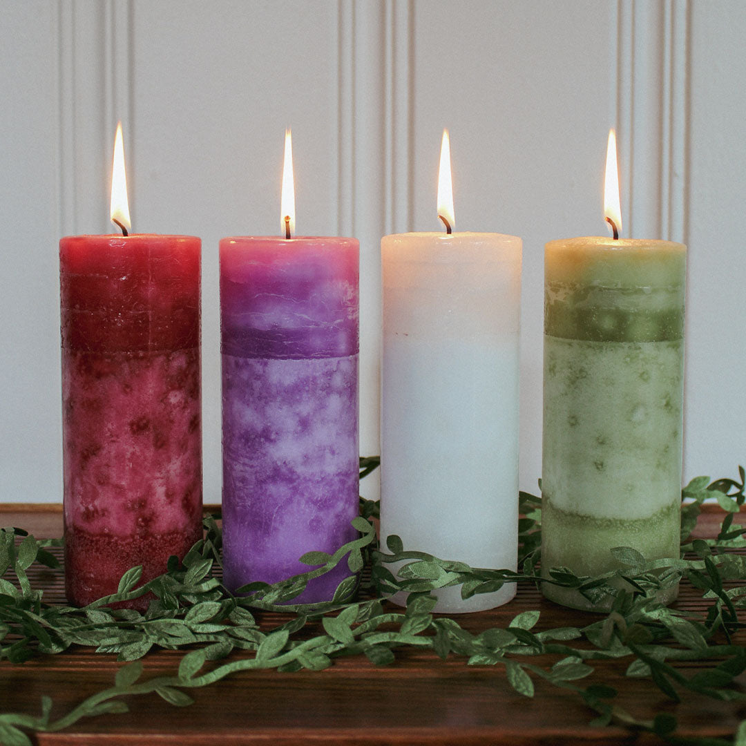 Red, Purple, White, and Green Pillar Candles lit