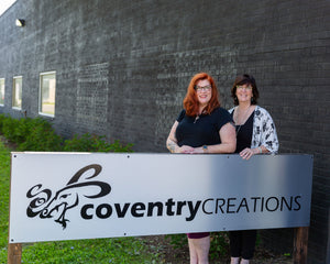 Jacki Smith and Patty Shaw standing in front of a Coventry Creations sign